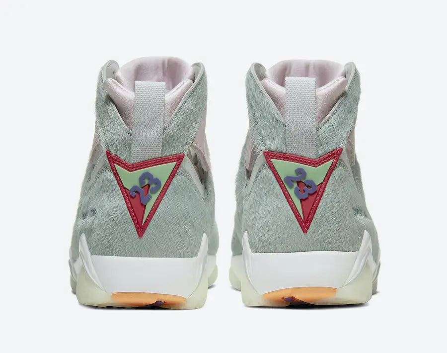 Air Jordan 7 Retro Neutral Grey en nuances gris clair et blanc avec tige montante, détails ton sur ton et semelle sculptée vue de derrière. 