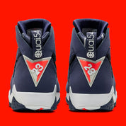 Air Jordan 7 Retro Quai 54 2022 DV0577-500 en suède et nubuck bleu marine avec accents Bright Crimson, semelle blanche et branding Quai 54 vue de derrière. 