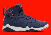 Air Jordan 7 Retro Quai 54 2022 DV0577-500 en suède et nubuck bleu marine avec accents Bright Crimson, semelle blanche et branding Quai 54 vue de profil. 