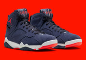 Air Jordan 7 Retro Quai 54 2022 DV0577-500 en suède et nubuck bleu marine avec accents Bright Crimson, semelle blanche et branding Quai 54 vue de 3/4 face. 
