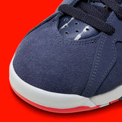 Vue zoomée sur la toe box de la Air Jordan 7 Retro Quai 54 2022 DV0577-500 en suède et nubuck bleu marine avec accents Bright Crimson, semelle blanche et branding Quai 54.