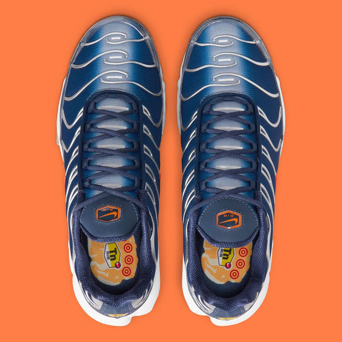 Nike Air Max Plus Syracuse bleu marine avec cage TPU gris argenté, Swoosh orange et unités Tuned Air visibles vue du dessus. 