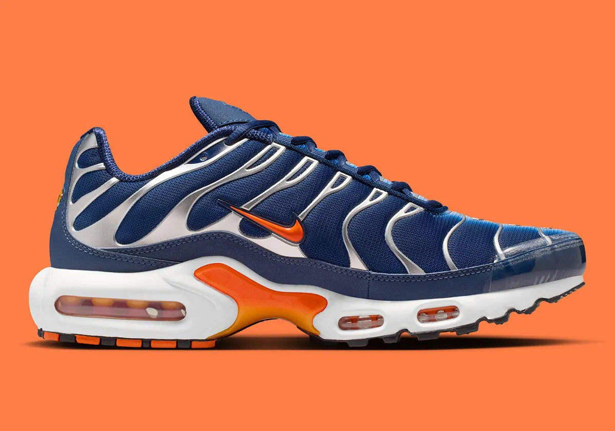 Nike Air Max Plus Syracuse bleu marine avec cage TPU gris argenté, Swoosh orange et unités Tuned Air visibles vue de profil intérieur. 