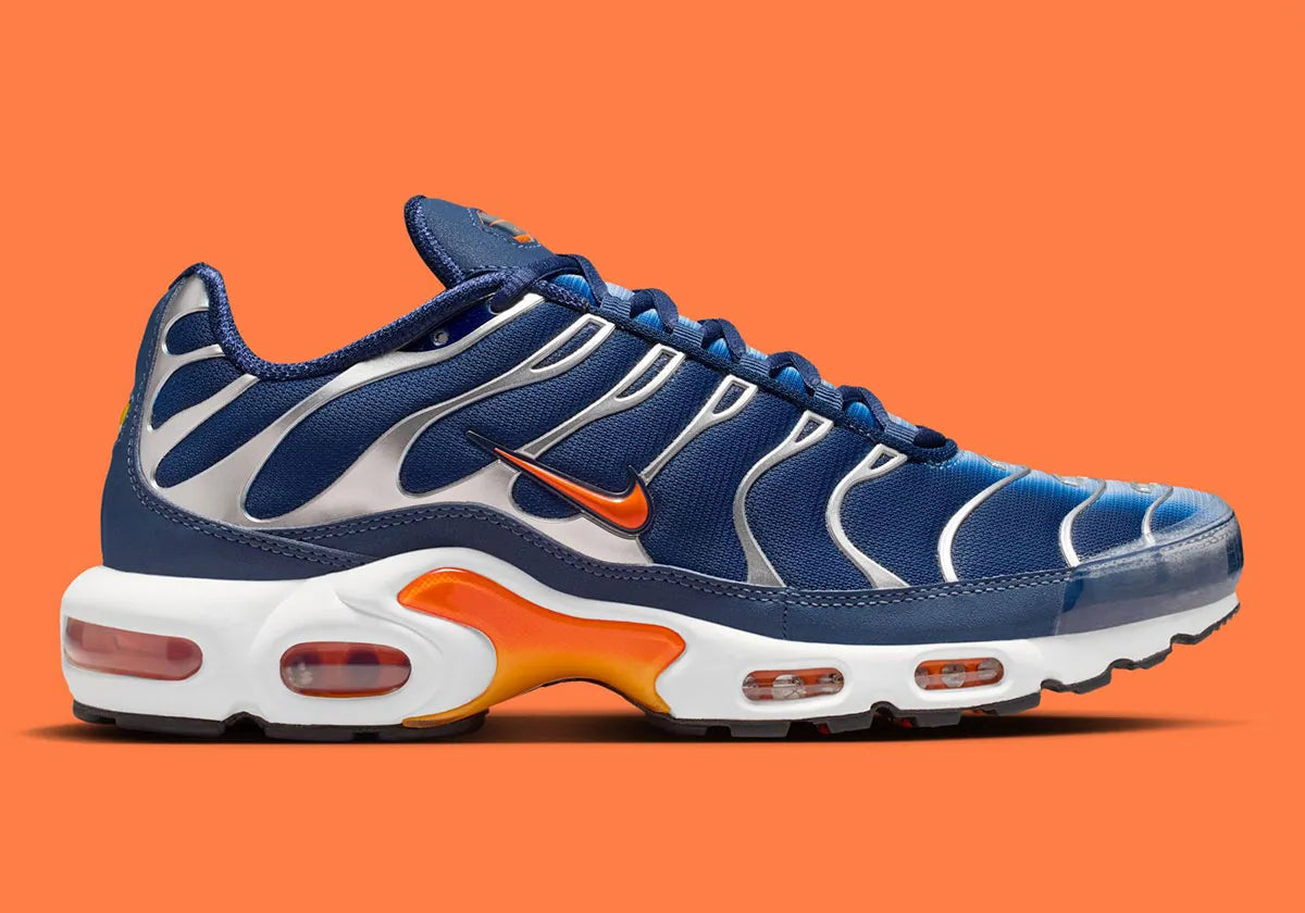 Nike Air Max Plus Syracuse bleu marine avec cage TPU gris argenté, Swoosh orange et unités Tuned Air visibles vue de profil. 