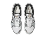 ASICS GEL-KAYANO 12.1 blanche, gris graphite et brune, avec tige en mesh respirant, empiècements synthétiques, amorti GEL et semelle extérieure en caoutchouc.