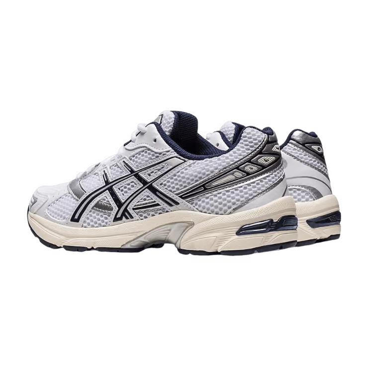 Image de la ASICS GEL-1130 White / Midnight : sneaker blanche avec détails bleu nuit Midnight, tige mesh/cuir, amorti GEL visible. (vue de 3/4 arrière)