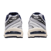 Image de la ASICS GEL-1130 White / Midnight : sneaker blanche avec détails bleu nuit Midnight, tige mesh/cuir, amorti GEL visible. (vue de derrière)