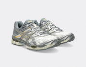 Sneaker ASICS Gel-Cumulus 16 Cream Clay Grey en mesh crème avec détails gris argile, amorti GEL et silhouette rétro-running premium.