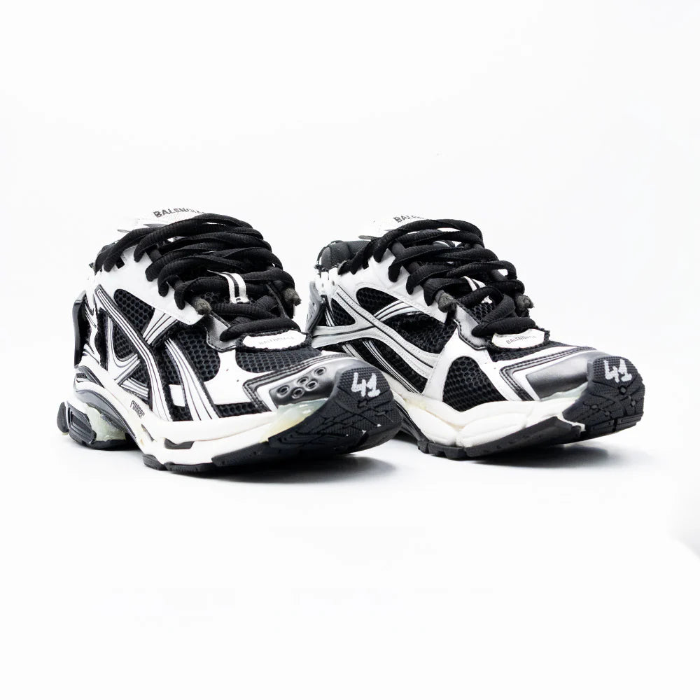 Balenciaga Runner Black White avec tige en mesh respirant, empiècements en cuir et matières synthétiques noirs et blancs, silhouette running déstructurée et semelle épaisse en caoutchouc.