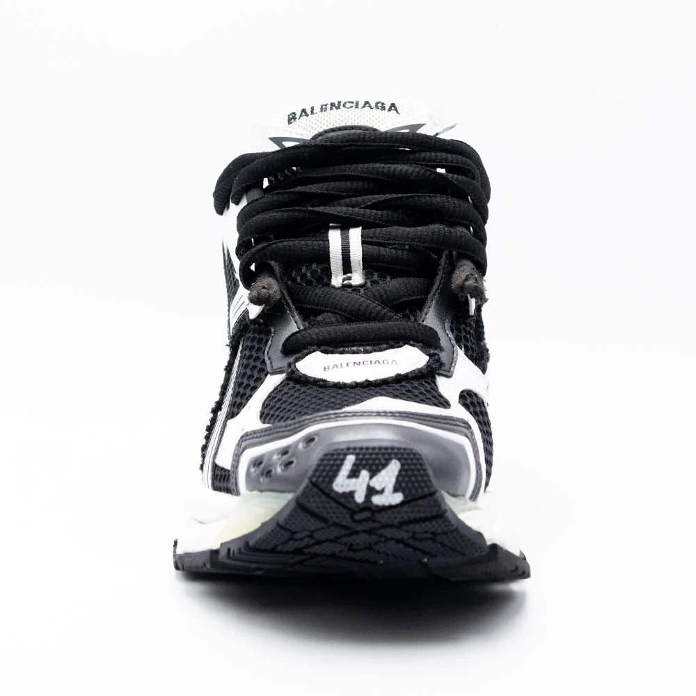 Balenciaga Runner Black White avec tige en mesh respirant, empiècements en cuir et matières synthétiques noirs et blancs, silhouette running déstructurée et semelle épaisse en caoutchouc.
