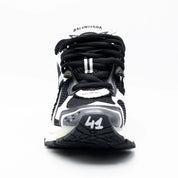 Balenciaga Runner Black White avec tige en mesh respirant, empiècements en cuir et matières synthétiques noirs et blancs, silhouette running déstructurée et semelle épaisse en caoutchouc.