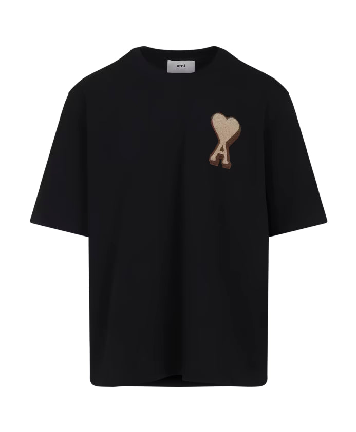 T-shirt AMI Paris noir en coton premium avec gros logo cœur beige brodé sur la poitrine.