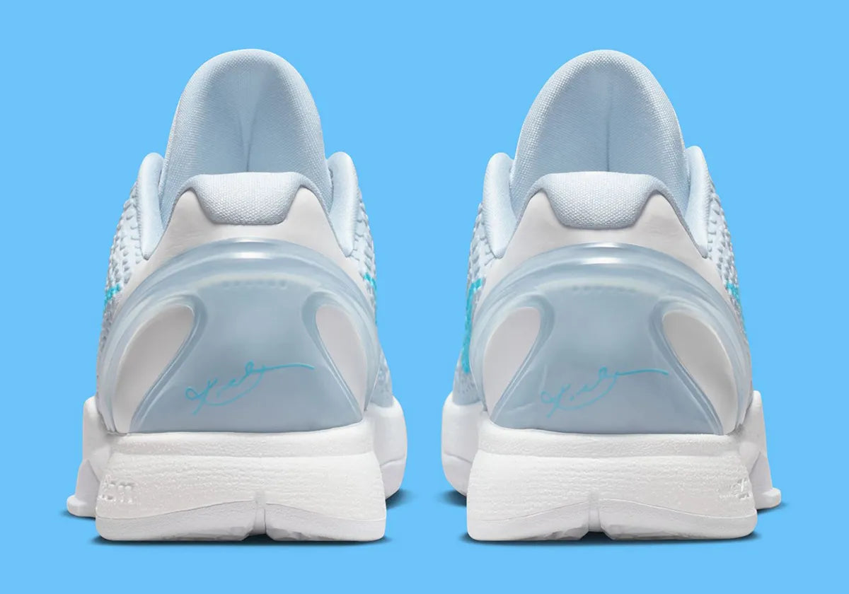 Image de la Nike Kobe 6 Protro “Caitlin Clark Light Armory Blue”, sneaker bleu glacier avec texture snakeskin, accents bleu baltic, semelle blanche, unité Zoom Air avant-pied. Vue de derrière.