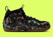 Nike Air Foamposite Pro Army Camo 2026, sneaker Nike Foamposite au motif camouflage vert kaki et noir avec coque moulée et Swoosh latéral.