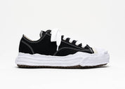 Découvrez la Maison Mihara Yasuhiro Hank OG Sole Canvas Low Black, une sneaker en toile noire avec semelle OG Sole sculptée en caoutchouc et silhouette basse au design expérimental.