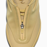 Converse SHAI 001 Butter, sneaker de basketball jaune crème monochrome avec empeigne moulée, fermeture zippée et silhouette futuriste.
