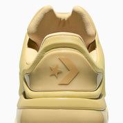 Converse SHAI 001 Butter, sneaker de basketball jaune crème monochrome avec empeigne moulée, fermeture zippée et silhouette futuriste.