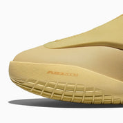 Converse SHAI 001 Butter, sneaker de basketball jaune crème monochrome avec empeigne moulée, fermeture zippée et silhouette futuriste.