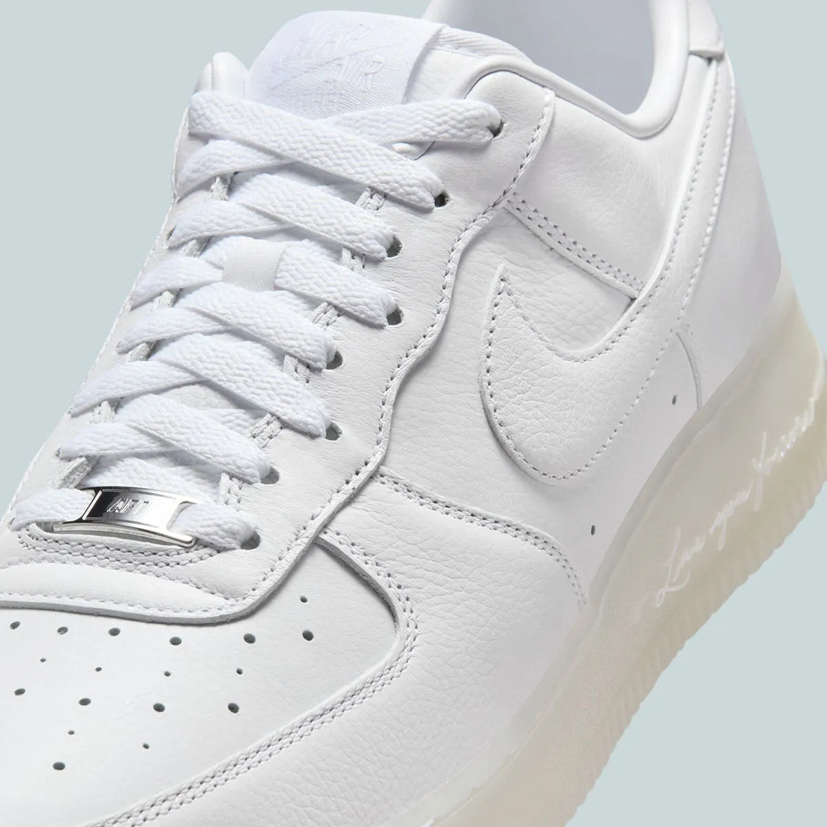 Nike Air Force 1 Low Drake NOCTA Certified Lover Boy White Cobalt Tint, sneaker Air Force 1 blanche et bleu Cobalt clair signée Drake NOCTA avec détails Love You Forever.