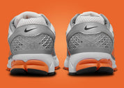 Nike Zoom Vomero 5 en mesh respirant avec renforts synthétiques, coloris Platinum Tint et accents Safety Orange, amorti Zoom Air réactif. vue de derrière