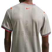 Palace x Nike England Dri-FIT Academy Pro Football Top Pewter Grey Bright Crimson 2 en tissu technique léger, technologie Nike Dri-FIT, base grise et détails rouge Bright Crimson.