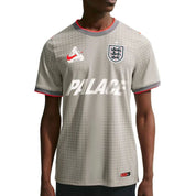 Palace x Nike England Dri-FIT Academy Pro Football Top Pewter Grey Bright Crimson 2 en tissu technique léger, technologie Nike Dri-FIT, base grise et détails rouge Bright Crimson.