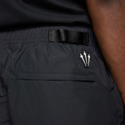 Nike x NOCTA Drake Northstar Nylon Track Pants Anthracite Grey, pantalon de survêtement en nylon gris anthracite avec poches zippées et logos NOCTA.