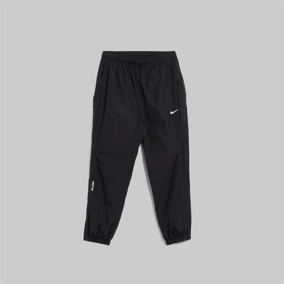 Nike x NOCTA Drake Northstar Nylon Track Pants Anthracite Grey, pantalon de survêtement en nylon gris anthracite avec poches zippées et logos NOCTA.