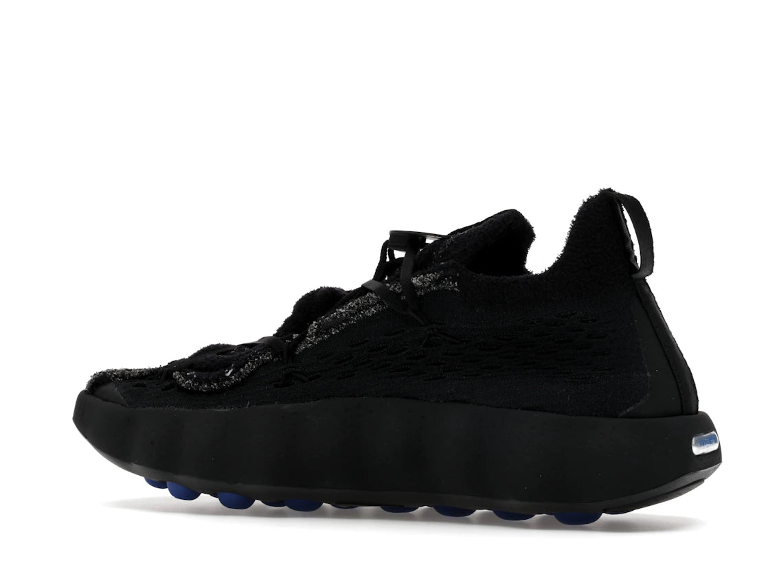 Nike Mind 002 Flyknit Fragment Black en maille Flyknit noire avec semelle sculptée ergonomique et détails signature Fragment Design.