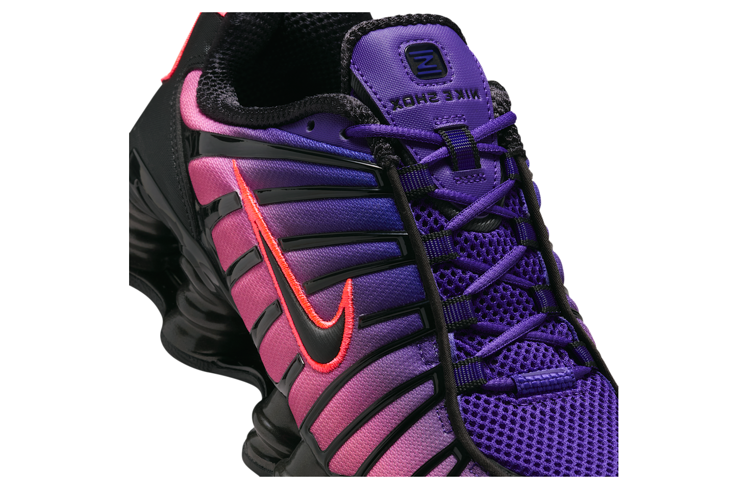 Vue zoomée sur les détails latéraux de la sneakers Nike Shox TL en maille respirante et renforts synthétiques, coloris Court Purple et Hot Lava avec colonnes Shox amortissantes.