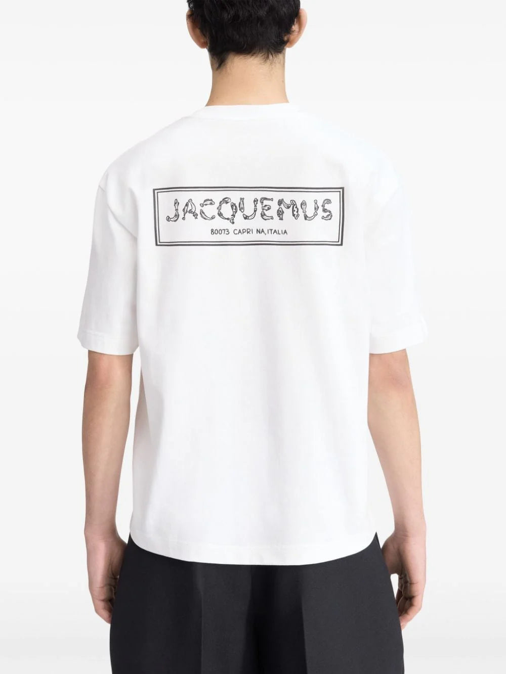 TEE SHIRT JACQUEMUS BLANC AVEC UN LOGO "J" EN FORME DE POISSON SUR LE COEUR ET UN GROS CADRE INSCRIT JACQUEMUS AU DOS DU TEE-SHIRT
