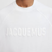 Image du tee-shirt JACQUEMUS Typo Blanc Logo Blanc, en coton blanc premium, avec logo typographique ton sur ton discret et coupe droite contemporaine