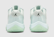 Air Jordan 11 Retro Low JAIDE IW1882-300 en coloris Fiberglass bleu-vert avec mudguard en cuir verni et logo JAIDE au talon.