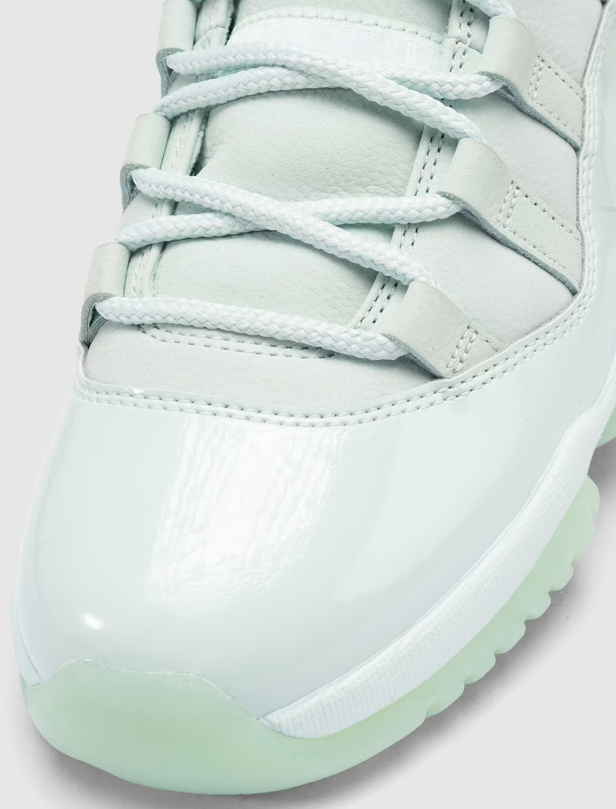 Air Jordan 11 Retro Low JAIDE IW1882-300 en coloris Fiberglass bleu-vert avec mudguard en cuir verni et logo JAIDE au talon.
