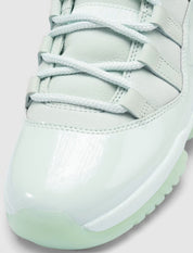Air Jordan 11 Retro Low JAIDE IW1882-300 en coloris Fiberglass bleu-vert avec mudguard en cuir verni et logo JAIDE au talon.