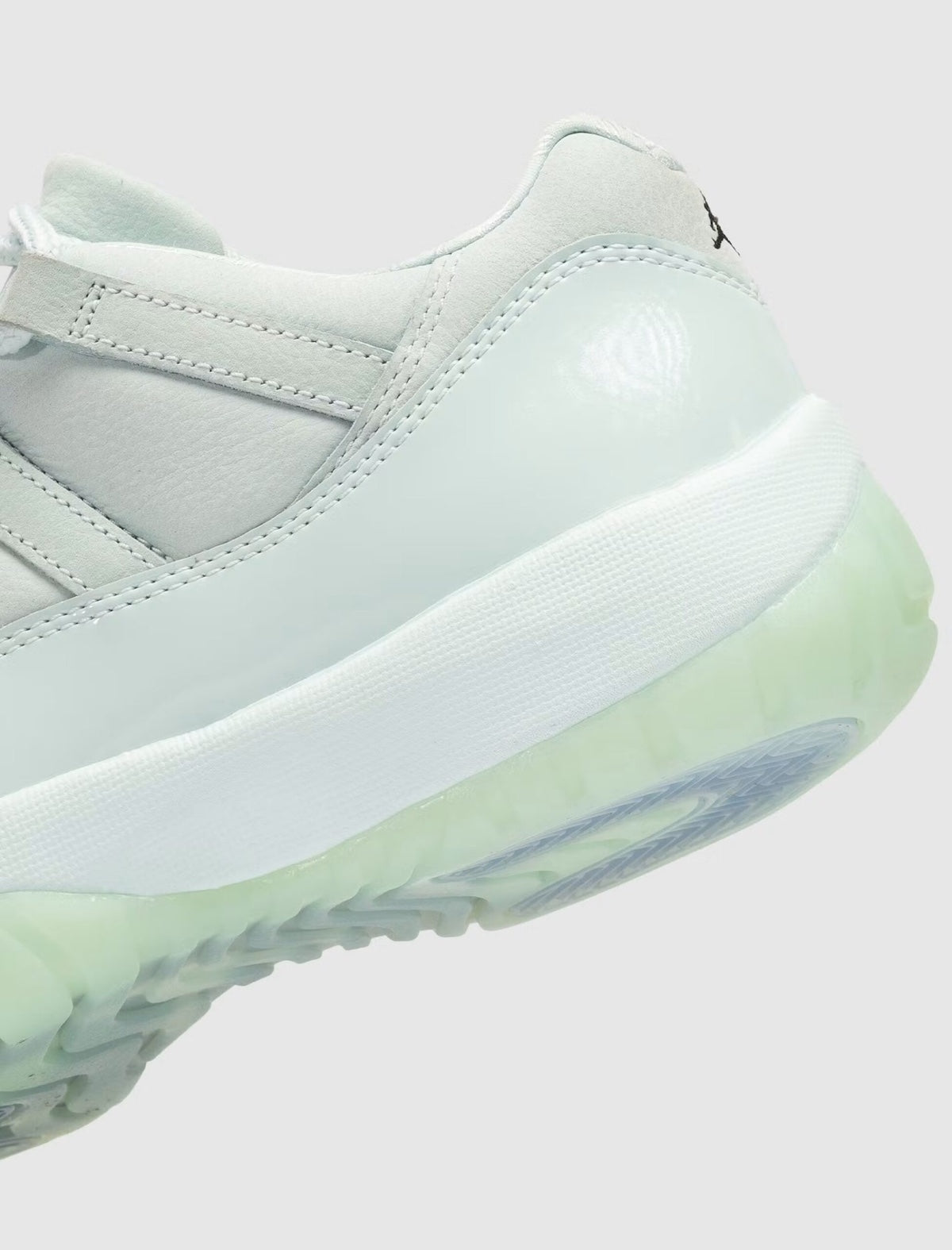 Air Jordan 11 Retro Low JAIDE IW1882-300 en coloris Fiberglass bleu-vert avec mudguard en cuir verni et logo JAIDE au talon.