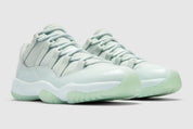 Air Jordan 11 Retro Low JAIDE IW1882-300 en coloris Fiberglass bleu-vert avec mudguard en cuir verni et logo JAIDE au talon.