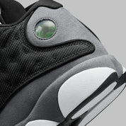 Vue zoomée sur les détails arrières de la Air Jordan 13 Retro Black Flint DJ5982-060 en cuir blanc, suède Flint Grey et mesh noir réfléchissant avec Jumpman rouge.