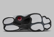 Air Jordan 13 Retro Black Flint DJ5982-060 en cuir blanc, suède Flint Grey et mesh noir réfléchissant avec Jumpman rouge vue de dessous. 
