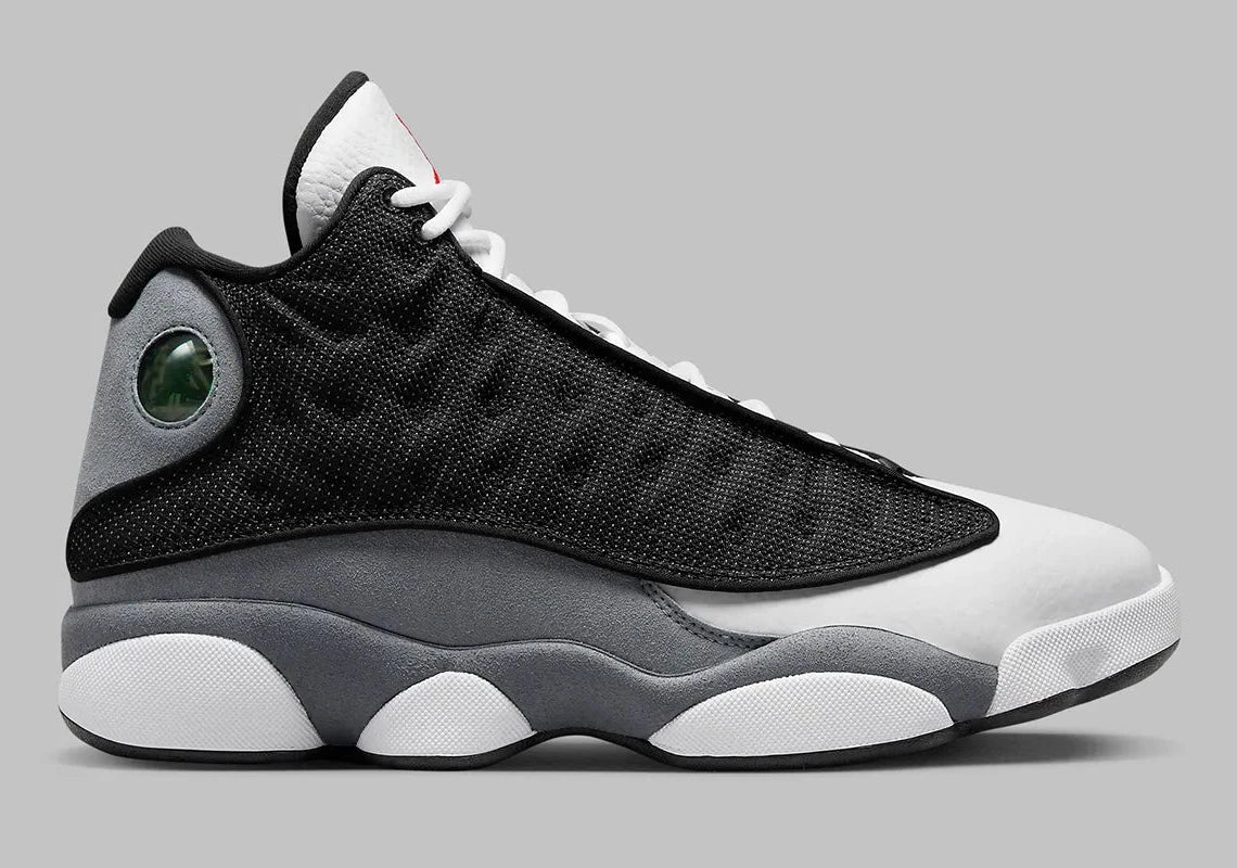 Air Jordan 13 Retro Black Flint DJ5982-060 en cuir blanc, suède Flint Grey et mesh noir réfléchissant avec Jumpman rouge vue de profil. 