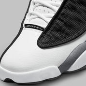 Vue zoomée sur la toe box de la Air Jordan 13 Retro Black Flint DJ5982-060 en cuir blanc, suède Flint Grey et mesh noir réfléchissant avec Jumpman rouge.