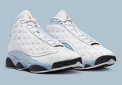 Air Jordan 13 Retro Blue Grey 414571-170 en cuir blanc avec panneaux Blue Grey, détails noirs, accents Yellow Ochre et hologramme vert vue de 3/4 face. 