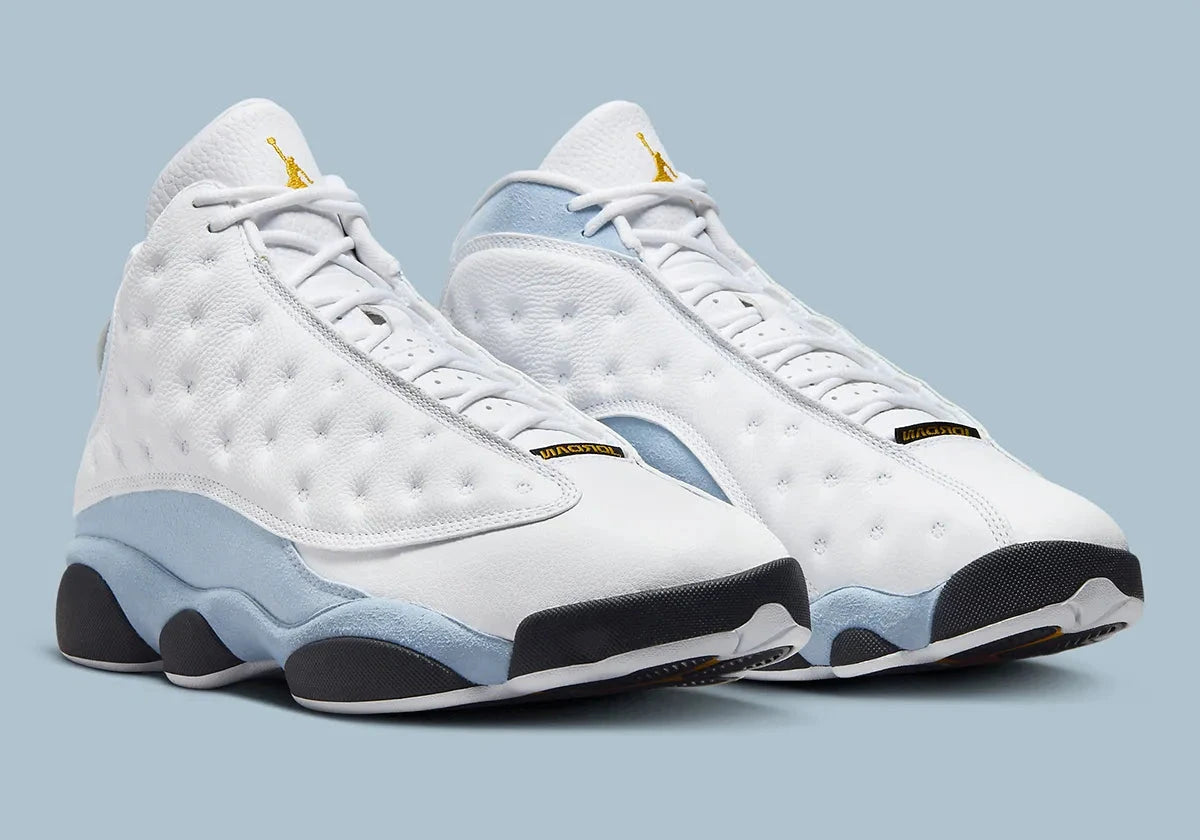 Air Jordan 13 Retro Blue Grey 414571-170 en cuir blanc avec panneaux Blue Grey, détails noirs, accents Yellow Ochre et hologramme vert vue de 3/4 face. 