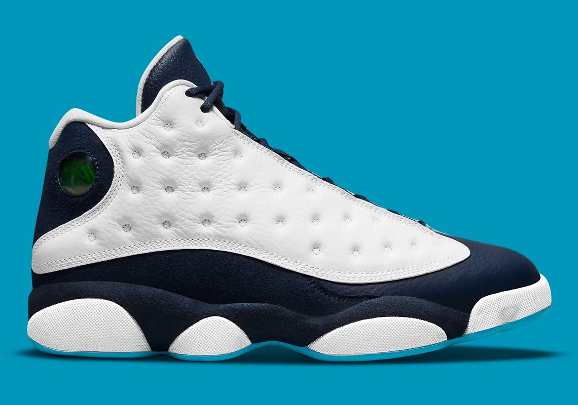 Air Jordan 13 Retro Obsidian Powder Blue White en cuir blanc foulonné avec renforts Obsidian, détails Dark Powder Blue et hologramme.