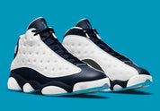 Air Jordan 13 Retro Obsidian Powder Blue White en cuir blanc foulonné avec renforts Obsidian, détails Dark Powder Blue et hologramme.