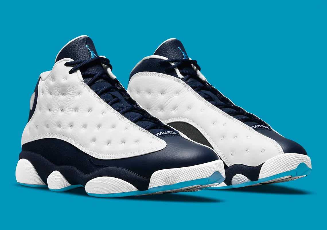 Air Jordan 13 Retro Obsidian Powder Blue White en cuir blanc foulonné avec renforts Obsidian, détails Dark Powder Blue et hologramme.