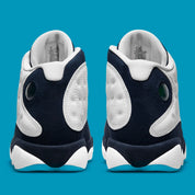 Air Jordan 13 Retro Obsidian Powder Blue White en cuir blanc foulonné avec renforts Obsidian, détails Dark Powder Blue et hologramme.