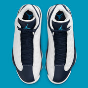 Air Jordan 13 Retro Obsidian Powder Blue White en cuir blanc foulonné avec renforts Obsidian, détails Dark Powder Blue et hologramme.