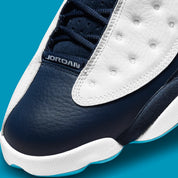 Air Jordan 13 Retro Obsidian Powder Blue White en cuir blanc foulonné avec renforts Obsidian, détails Dark Powder Blue et hologramme.