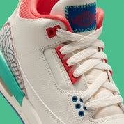 Vue zoomée sur les détails latéraux de la Air Jordan 3 Retro Play Your Way, sneaker Jordan Brand au design rétro basketball avec silhouette Air Jordan 3 et unité Nike Air visible au talon.